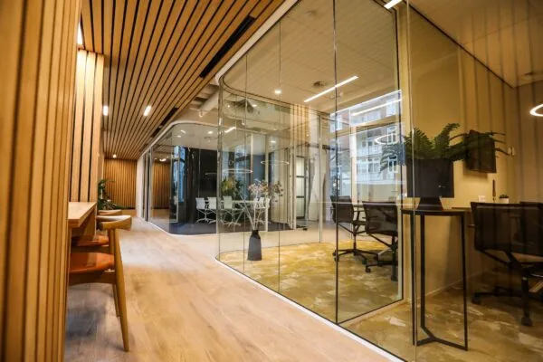 Moderne kantoorruimte met glazen vergaderruimtes, houten wandbekleding en designmeubilair.