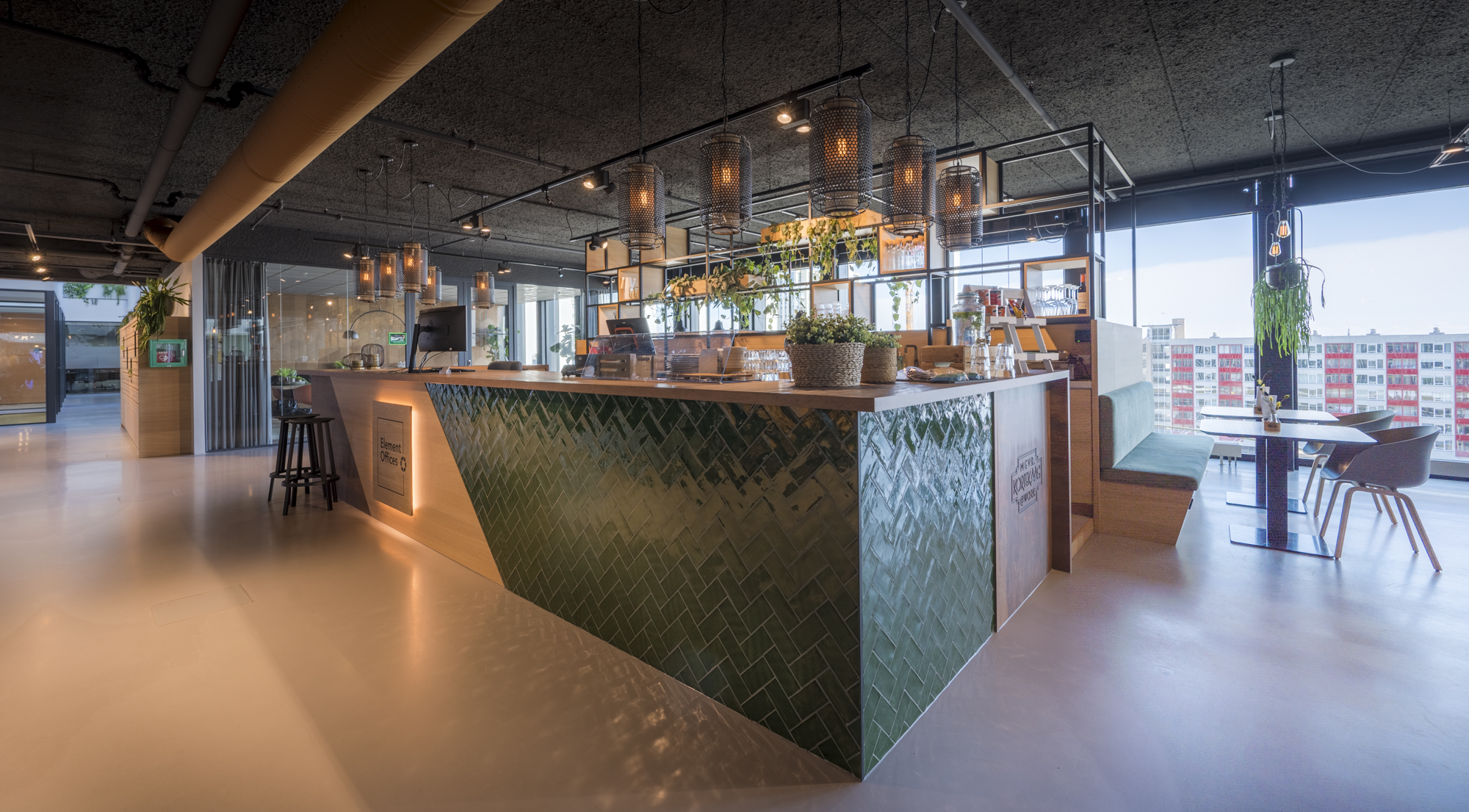 Een stijlvolle en moderne balie in een kantooromgeving, met groene tegels en sfeervolle verlichting.