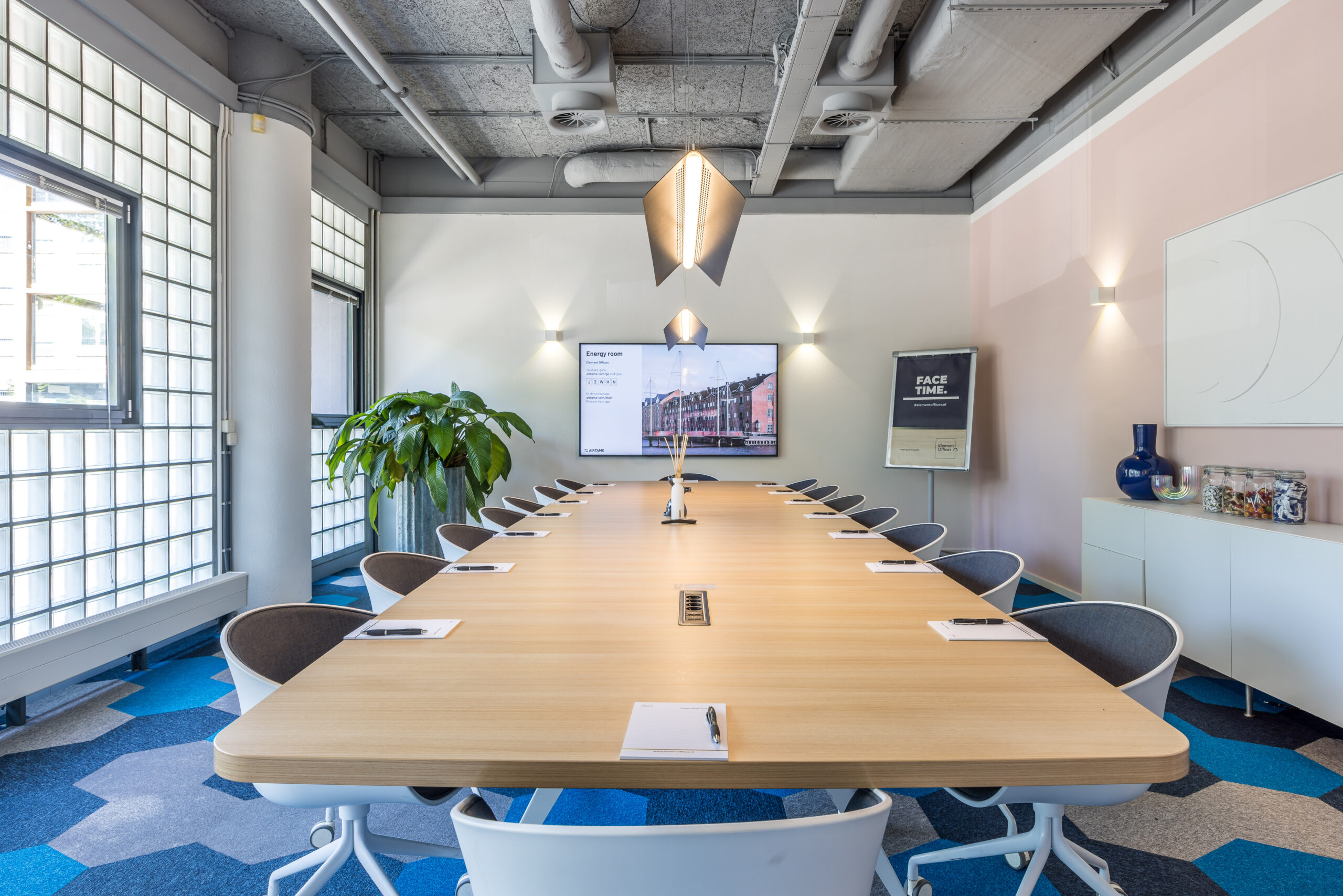 Moderne vergaderruimte in Element Offices, Utrecht, met een lange tafel, stoelen eromheen en een groot scherm aan de muur.