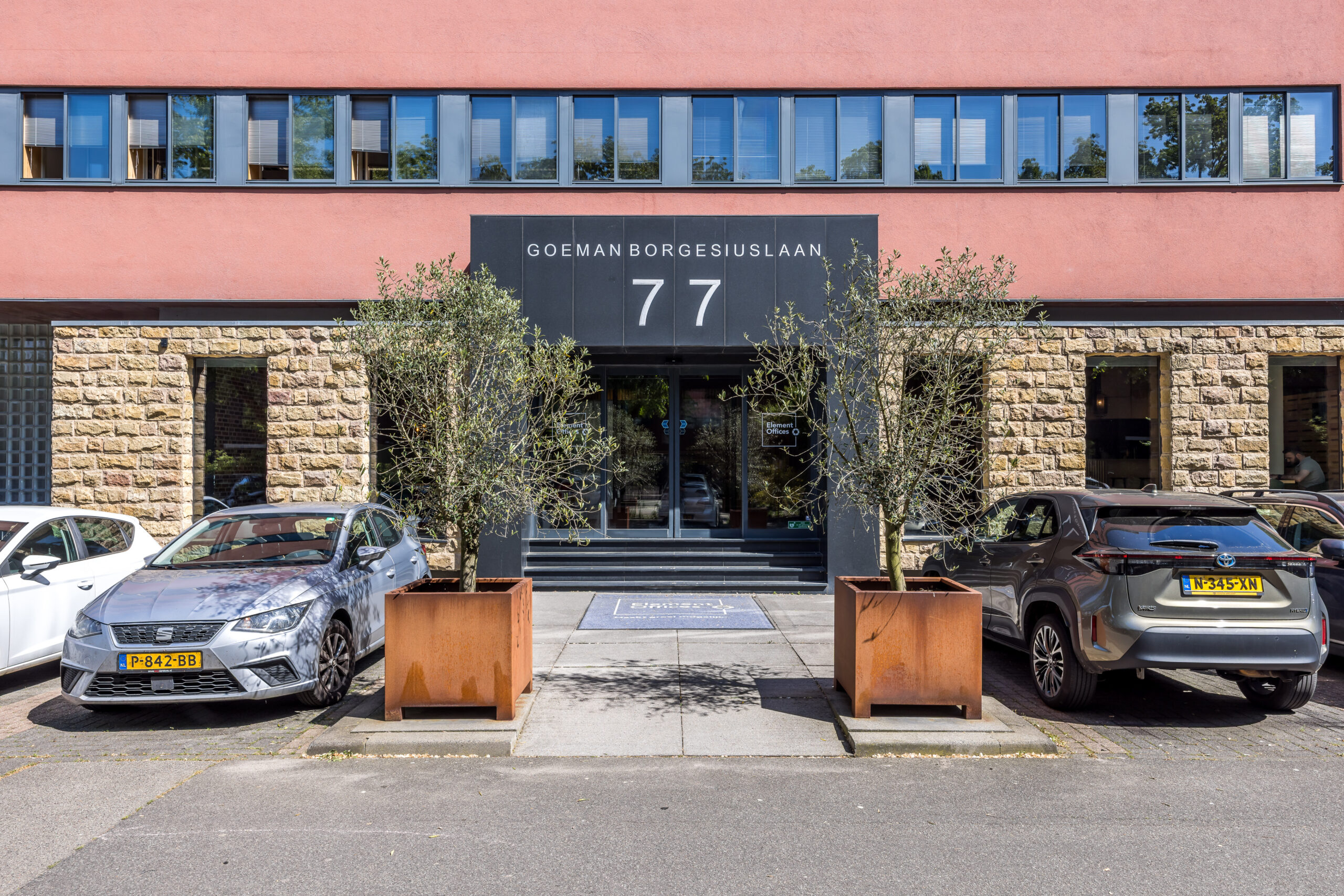 De hoofdingang van Element Offices aan de Goeman Borgesiuslaan 77 in Utrecht met geparkeerde auto's en plantenbakken.