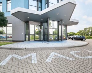 Ingang van een modern kantoorgebouw aan de Pascallaan 60-78 in Lelystad met parkeerplaatsen voor de deur.