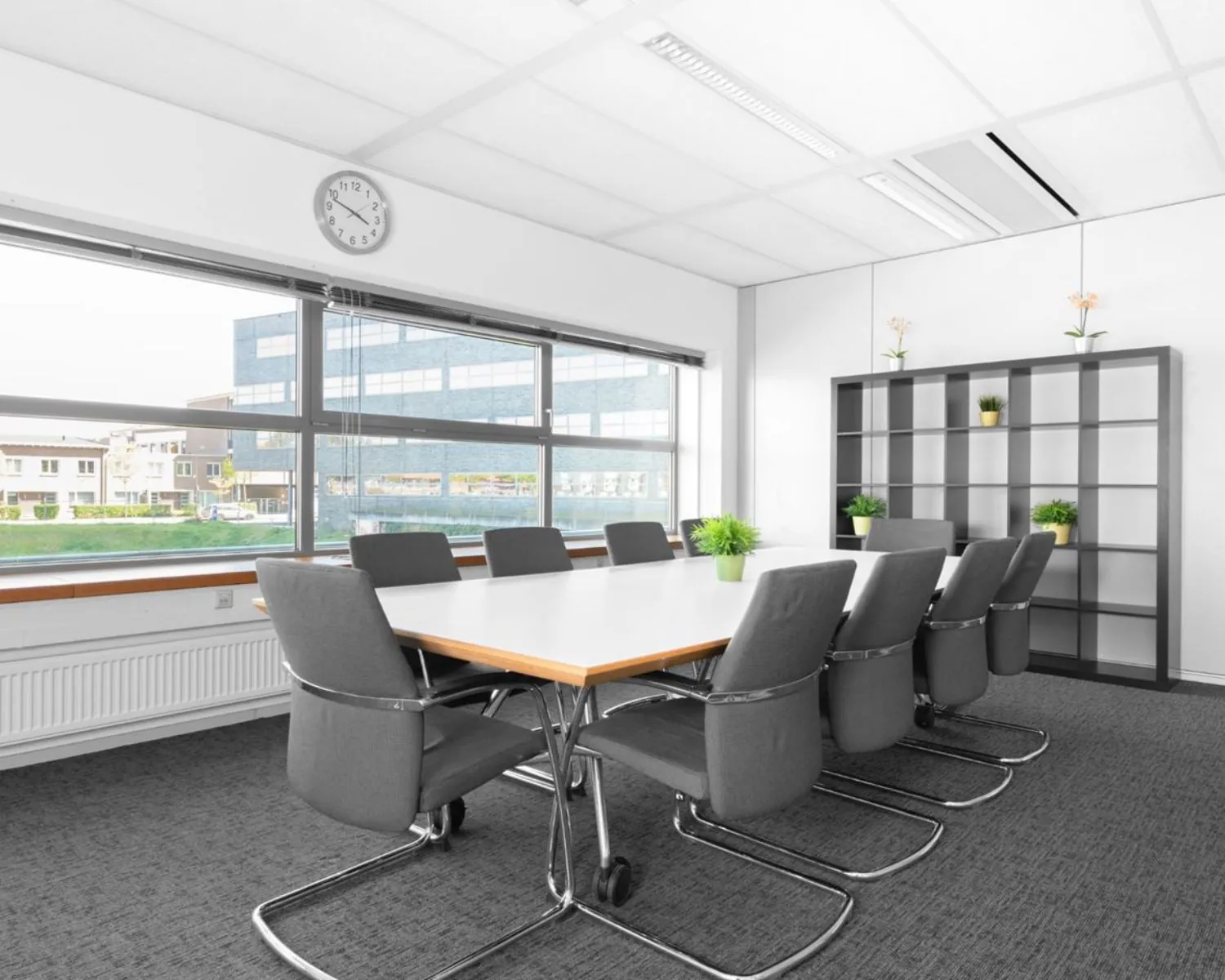 Vergaderruimte met moderne inrichting en uitzicht op kantoorpand bij Flight Forum 40 in Eindhoven.