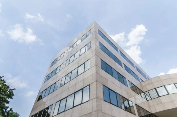 Hoekaanzicht van het moderne kantoorgebouw HNK Utrecht West onder een blauwe lucht.