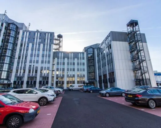 Kantoorcomplex aan de Gaetano Martinolaan 75-95 in Maastricht met parkeerplaats op de voorgrond.