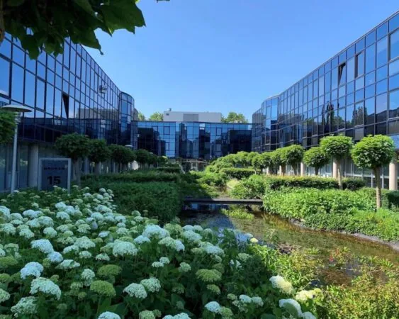 Moderne kantoorruimte aan de Elisabethhof in Leiderdorp met glazen gevels, weelderige tuinen en een sierlijke vijver.