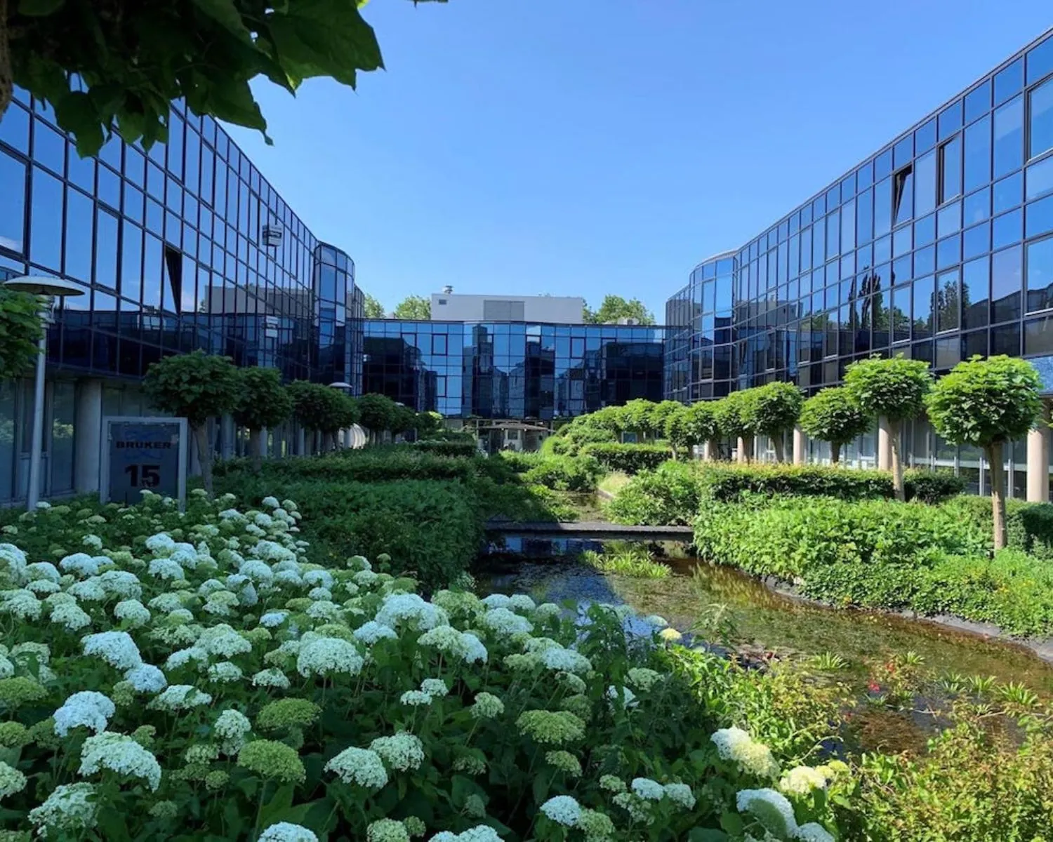 Moderne kantoorruimte aan de Elisabethhof in Leiderdorp met glazen gevels, weelderige tuinen en een sierlijke vijver.