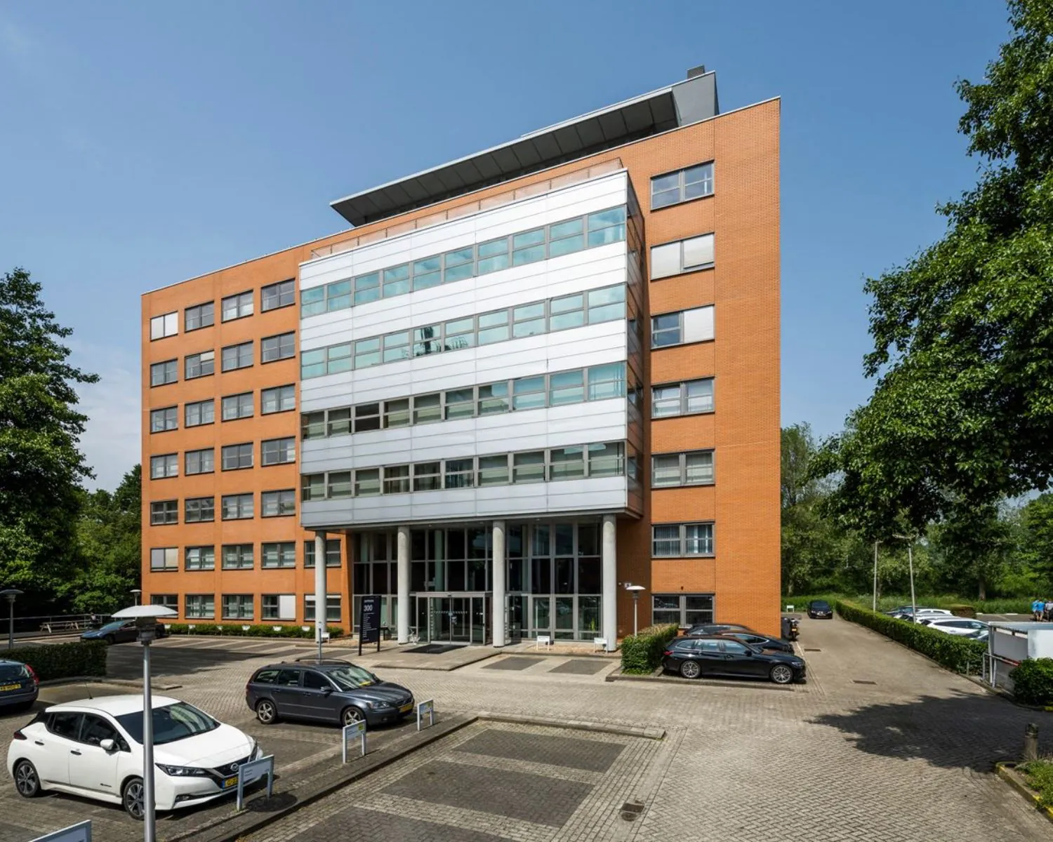 Voorgevel van kantoorgebouw Entrada 300 in Amsterdam met parkeergelegenheid op de voorgrond.