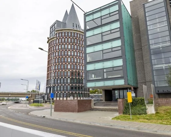 Moderne kantoorpanden aan de Looskade 20 in Roermond, met een opvallend rond torengebouw en glazen gevels.