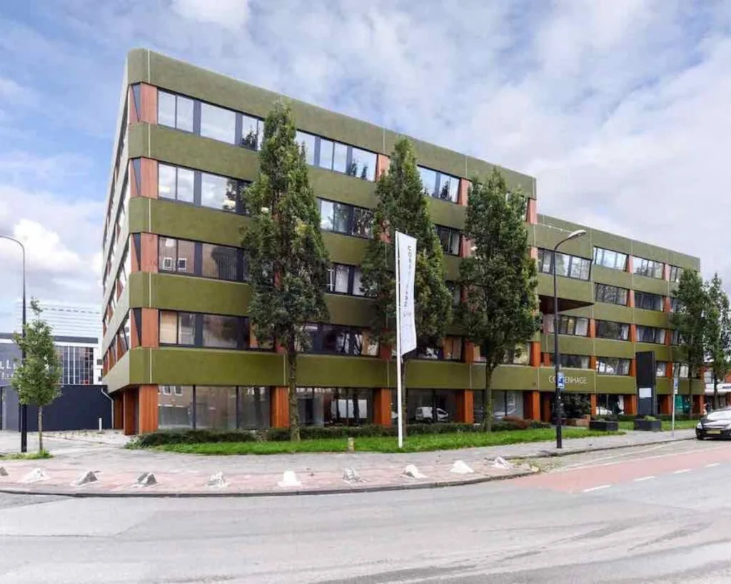 Groen-bruin kantoorgebouw aan de Treubstraat 1 in Rijswijk met meerdere verdiepingen en een moderne gevel.