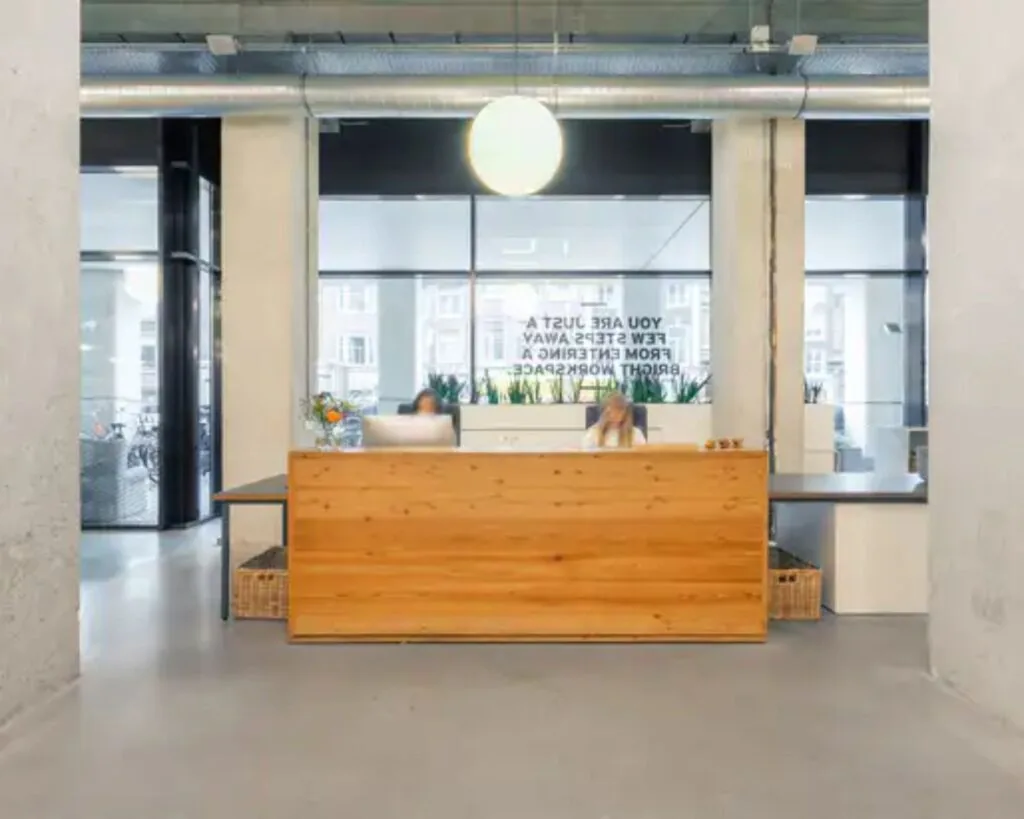 Moderne receptiebalie in een lichte kantoorruimte aan de Vijzelstraat 60 in Amsterdam.