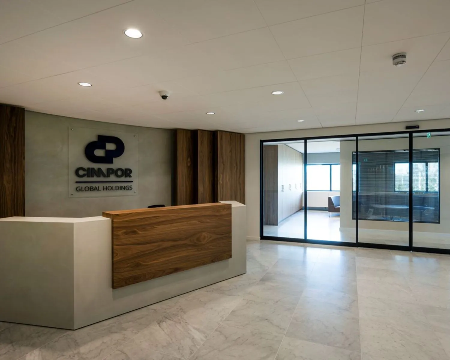 Moderne ontvangstruimte van een kantoorgebouw aan de Wegalaan 35 in Hoofddorp met balie en glazen scheidingswand.