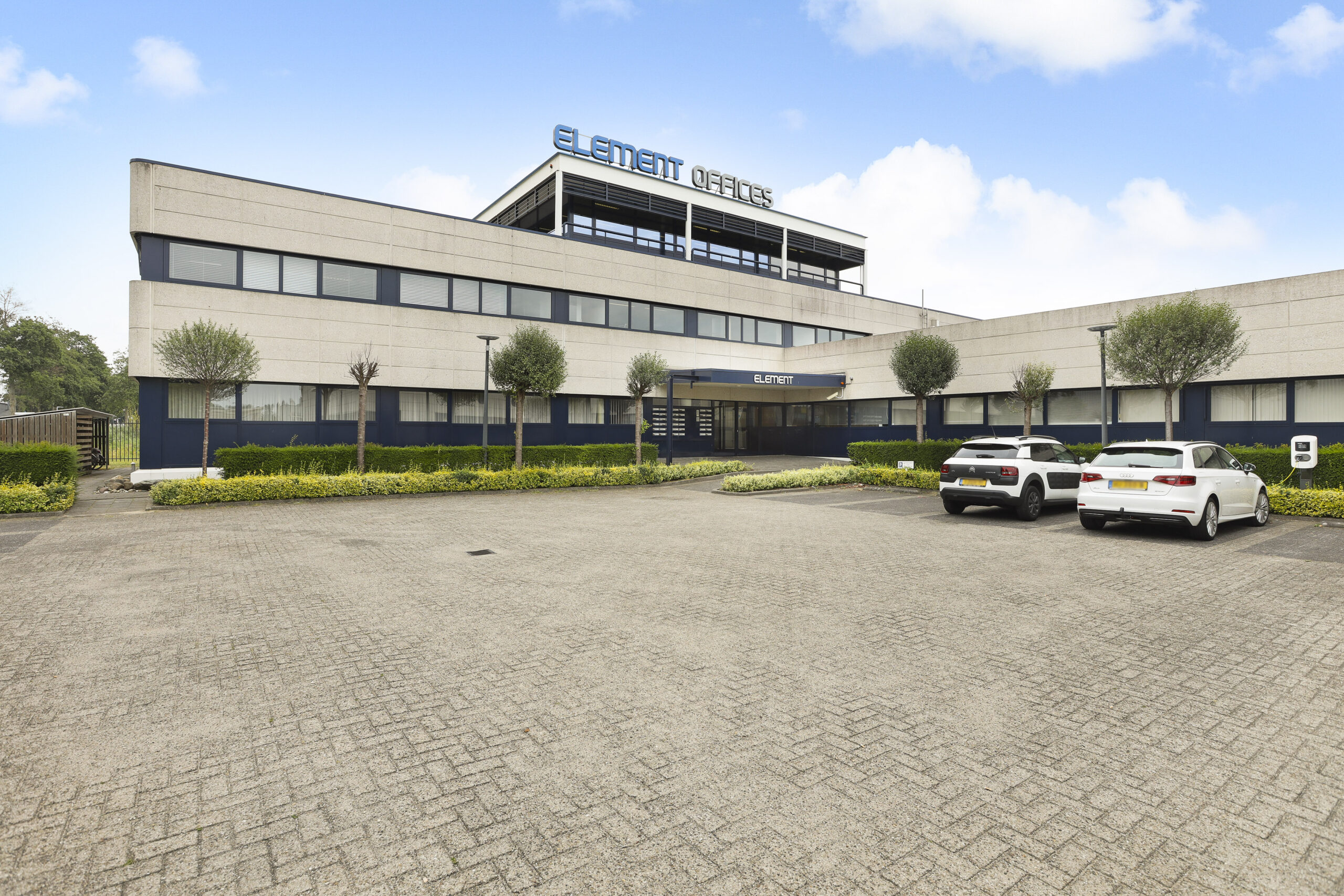 Buitenaanzicht van Element Offices op Markerkant 13 in Almere met parkeerplaats en auto's.
