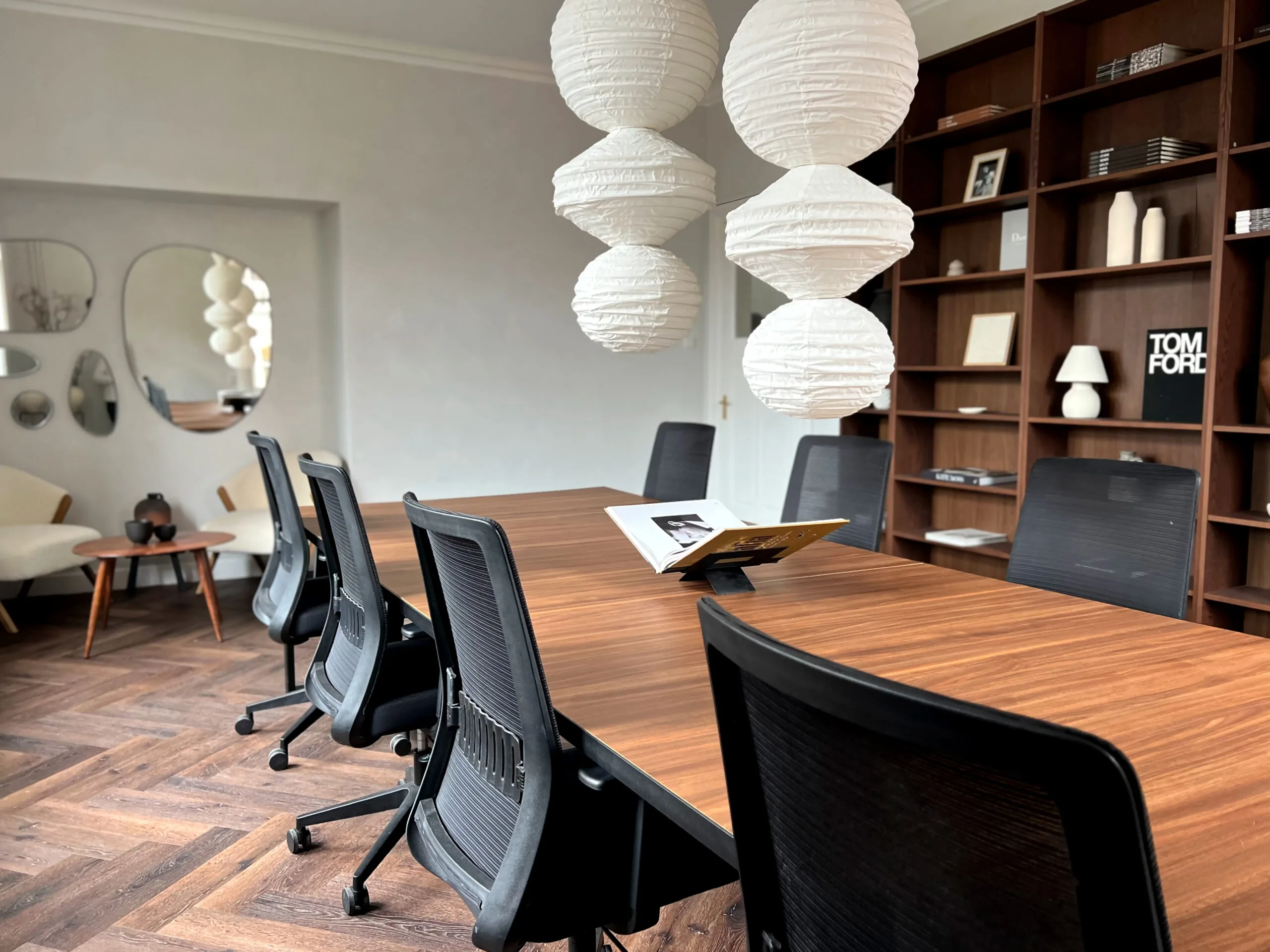 Moderne vergaderruimte bij Creativegrounds – Emmalaan met houten tafel, zwarte bureaustoelen en stijlvolle decoratie.