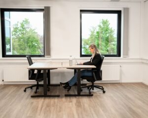 Vrouw werkt op laptop in lichte kantoorruimte aan de Bolderweg 2a in Almere.