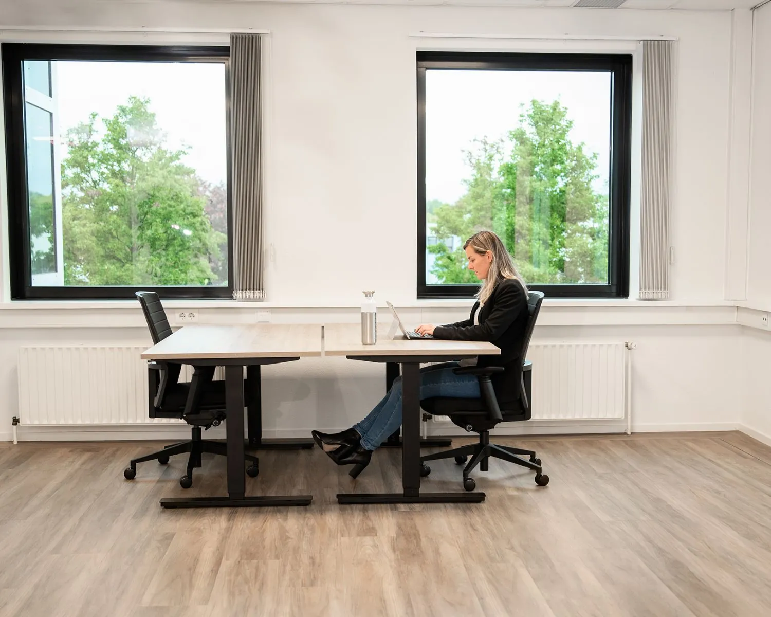 Vrouw werkt op laptop in lichte kantoorruimte aan de Bolderweg 2a in Almere.