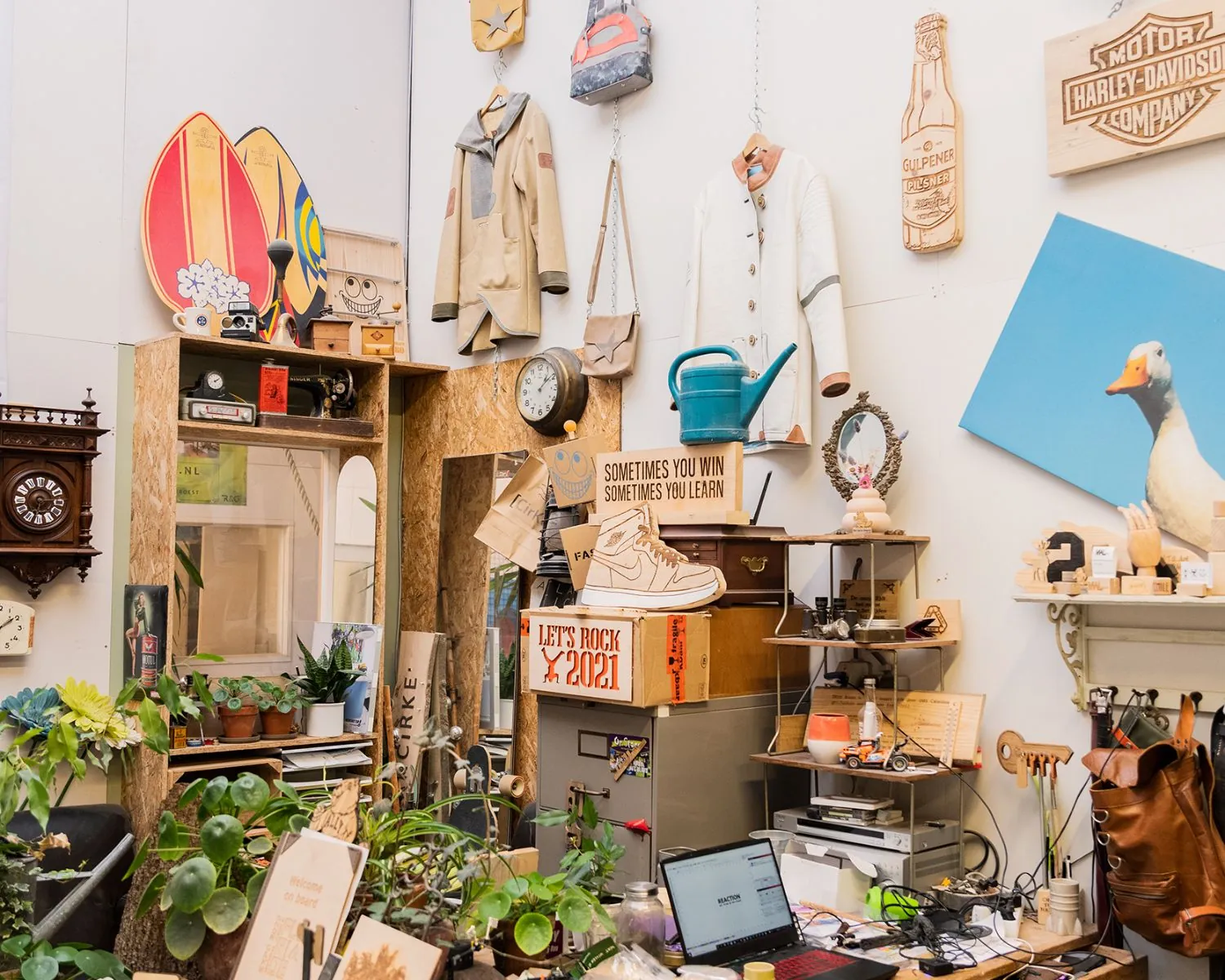 Creatief ingerichte kantoorruimte in Steiger 24 in Almere met vintage decoratie, planten en opvallende wandobjecten.