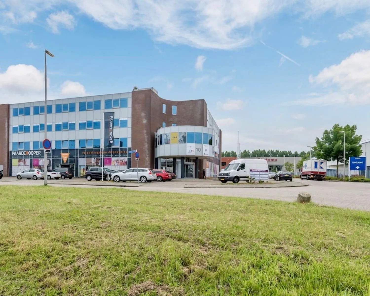 Modern kantoorpand aan de Kamerlingh Onnesweg 10 in Barendrecht met parkeerplaatsen en meerdere bedrijfsvoertuigen.