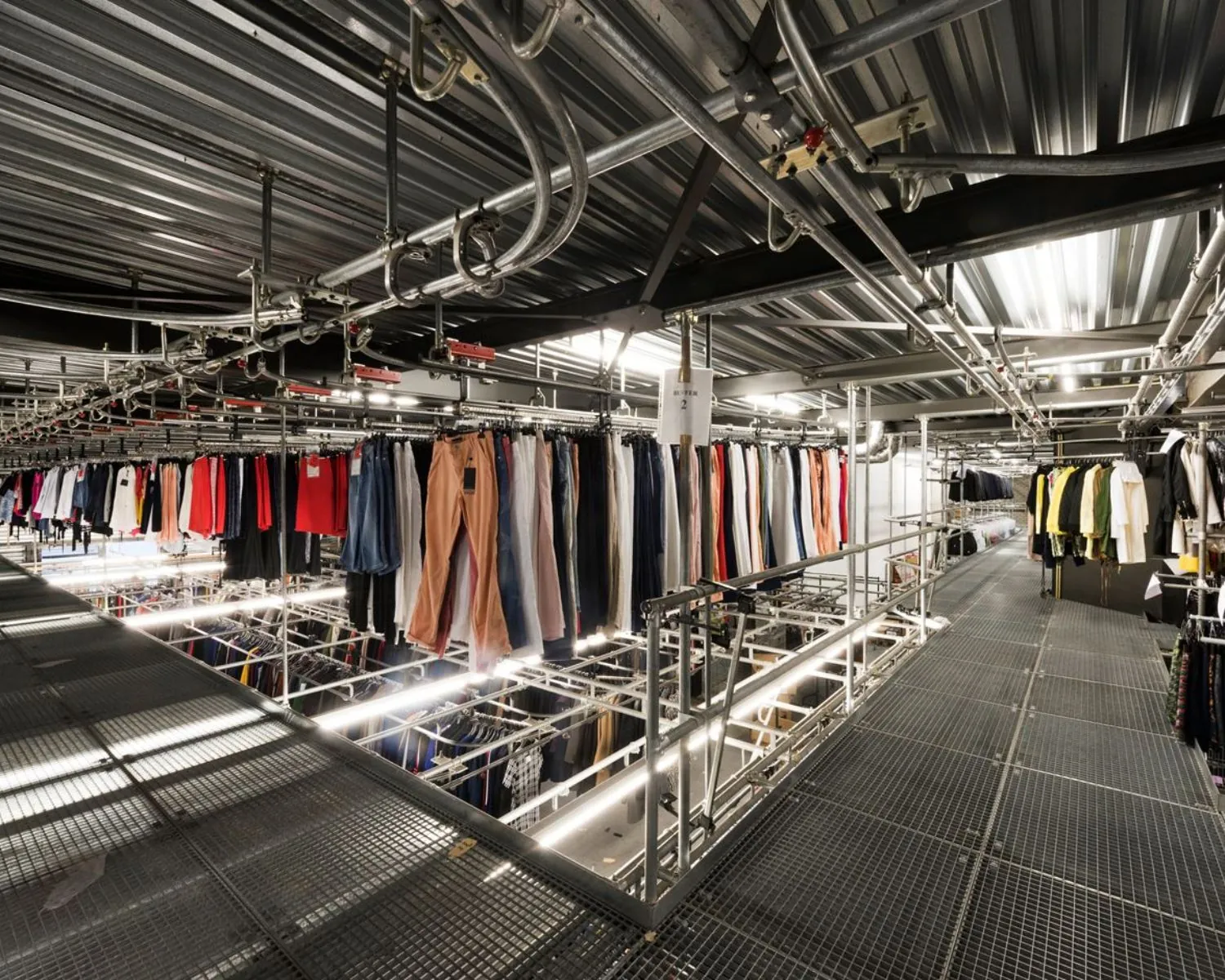 Industriële kledingopslag met metalen looppaden en railsystemen in een bedrijfsruimte aan Stammerhove 1 in Diemen.