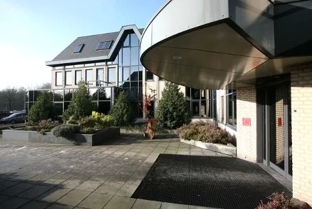 Moderne kantoorgebouw aan de Utrechtseweg met glazen gevel en aangelegde voortuin.