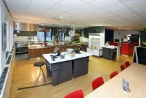 Ruime, moderne kantoorkeuken aan de Utrechtseweg met kookeilanden, zithoek en vergadertafel.