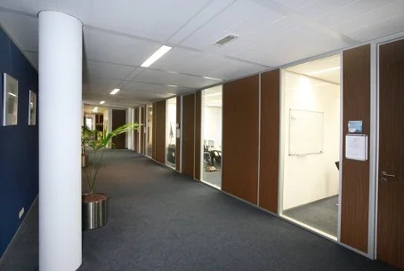 Gang met kantoorkamers en glazen wanden in een bedrijfsverzamelgebouw aan de Utrechtseweg.