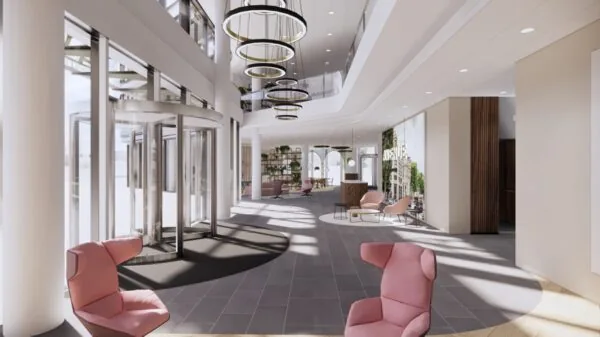 Moderne, lichte entreehal van een kantoorgebouw aan de Europalaan met designmeubilair en glazen draaideuren.