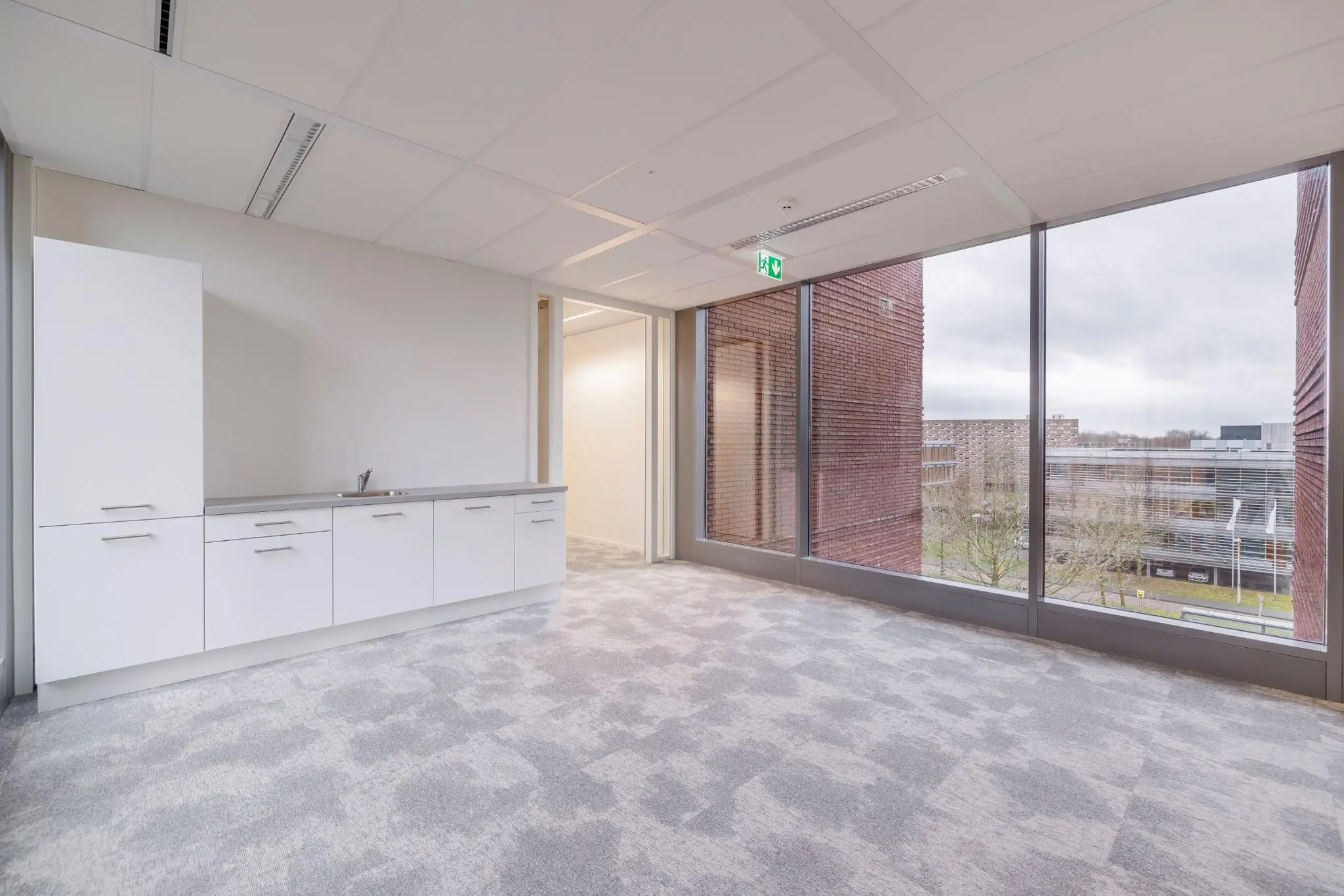 Moderne, lichte kantoorruimte aan de Mercatorlaan met pantry en grote ramen met uitzicht op omliggende gebouwen.