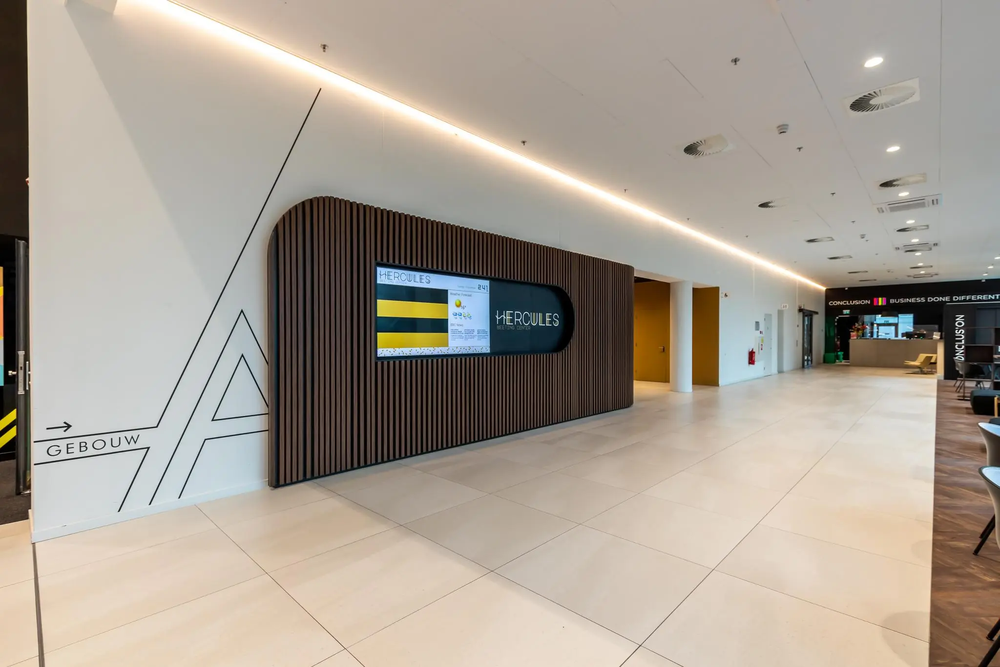 Moderne en strakke ontvangsthal van het Herculesplein met digitale informatiezuil en zicht op de lobby van Conclusion.