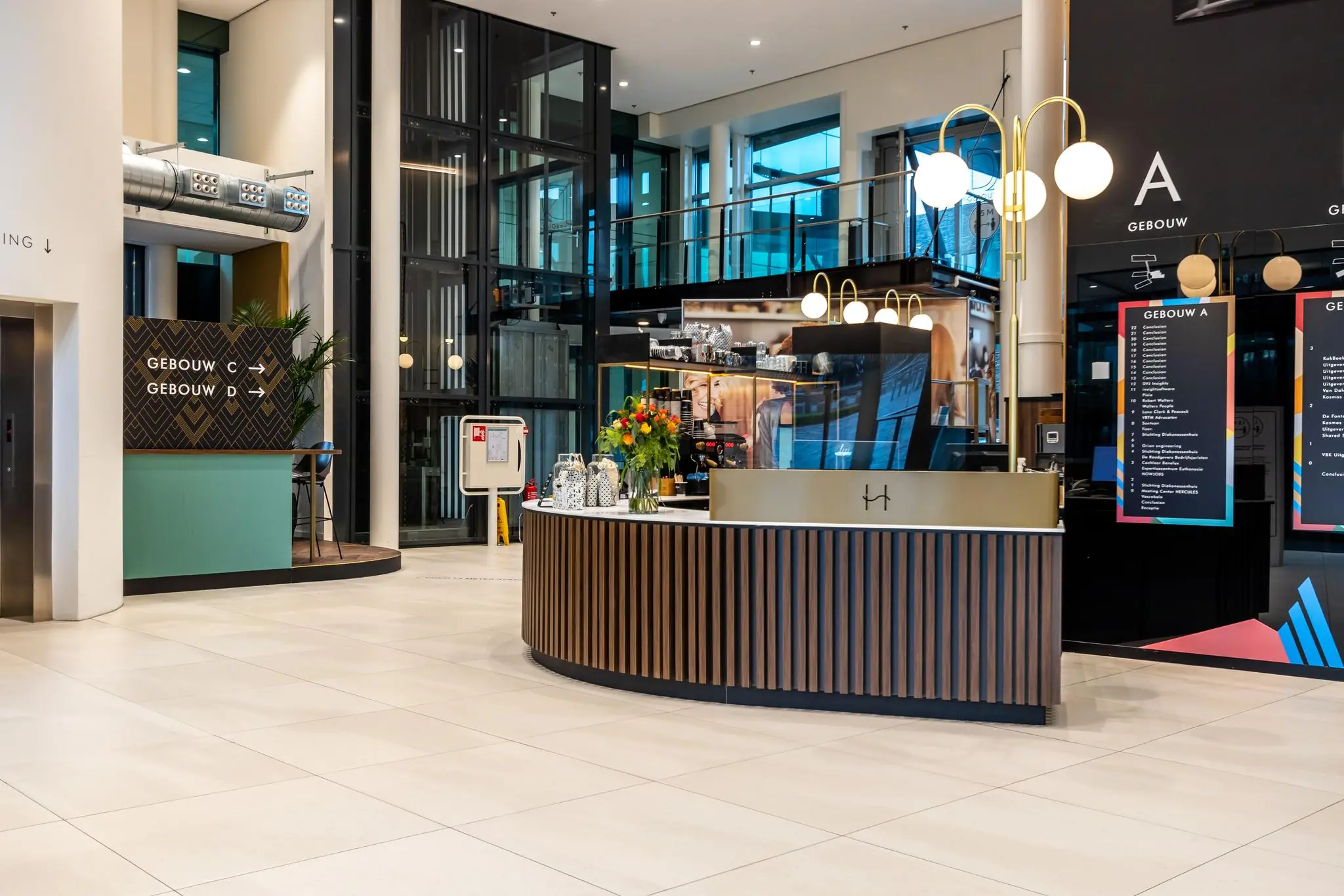 Moderne ontvangsthal van het Herculesplein met balie, bewegwijzering en liften naar gebouwen A, C en D.