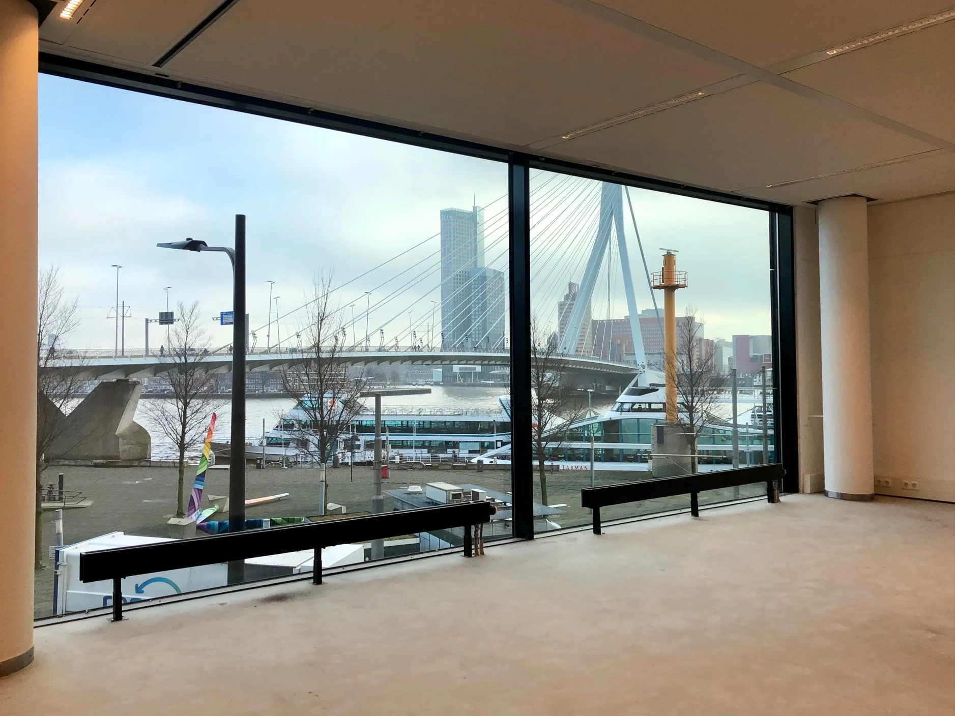 Uitzicht vanuit een kantoorgebouw op het Willemsplein in Rotterdam met de Erasmusbrug en skyline op de achtergrond.