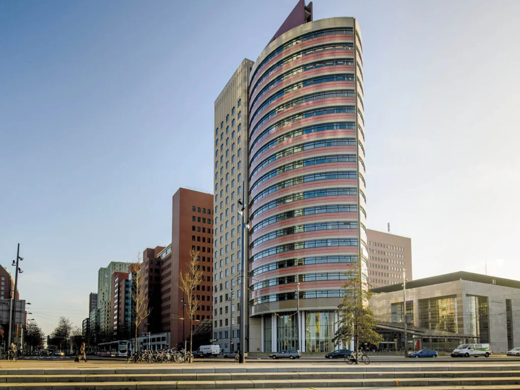 Modern kantoorgebouw aan het Wilhelminaplein in Rotterdam met opvallende ronde gevel en omringende hoogbouw.