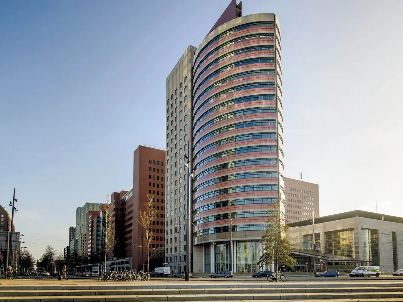 Modern kantoorgebouw aan het Wilhelminaplein in Rotterdam met opvallende ronde gevel en omringende hoogbouw.