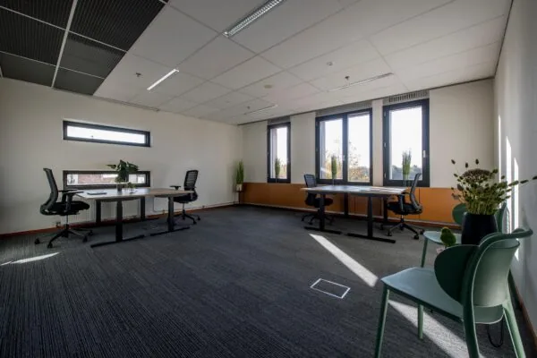 Modern ingericht kantoor aan de Fokkerstraat met bureaus, bureaustoelen en grote ramen die veel daglicht binnenlaten.