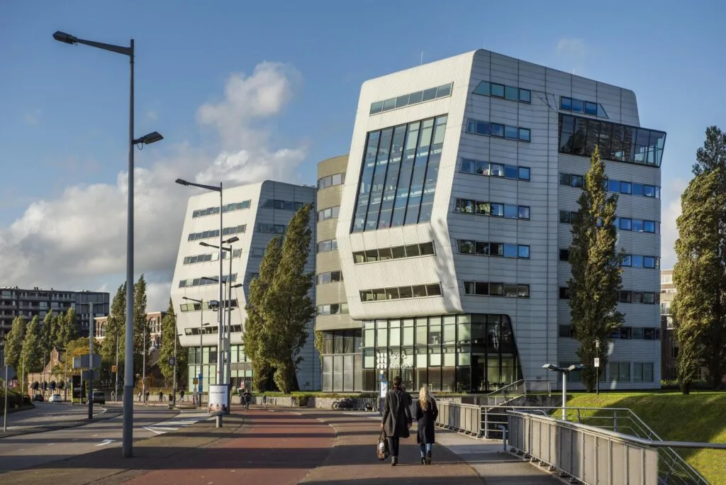 Modern kantoorgebouw aan het Rietlandpark in Amsterdam met opvallende schuine gevels en grote ramen.