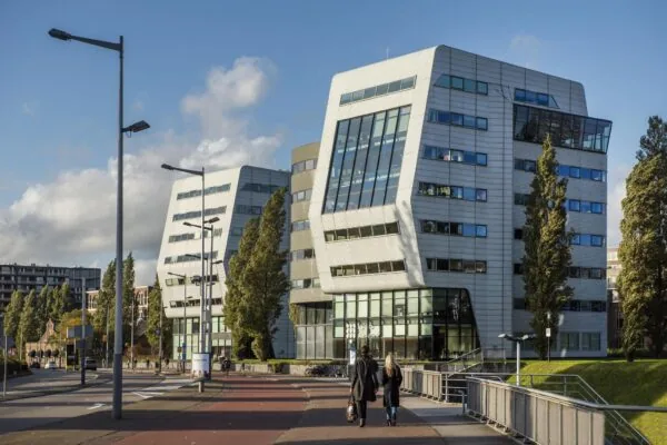 Modern kantoorgebouw aan het Rietlandpark in Amsterdam met opvallende schuine gevels en grote ramen.