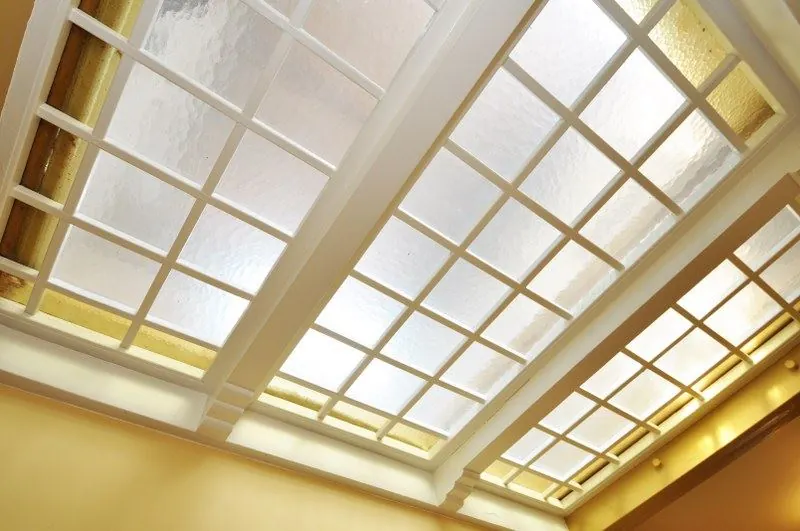 Glazen plafond met een wit houten raamwerk in een gang of entree aan de Spechtlaan.