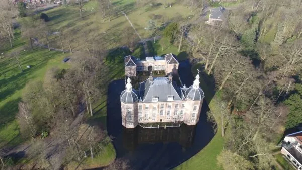 Luchtfoto van Kasteel Zeist aan de Kasteellaan, omringd door een slotgracht en groen parklandschap.