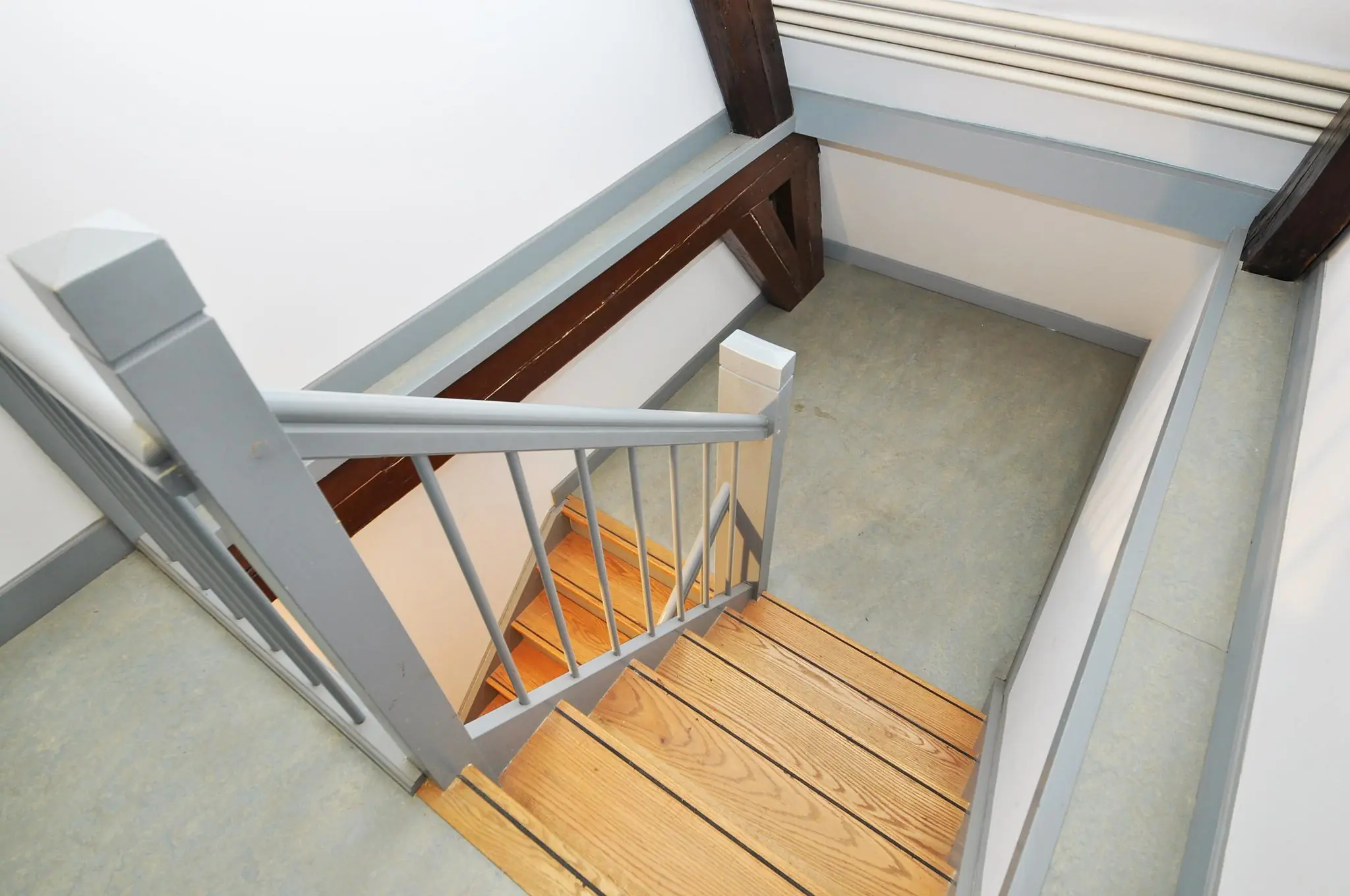 Houten trap met grijze leuning in een modern afgewerkte hoek van een woning aan de Kasteellaan.