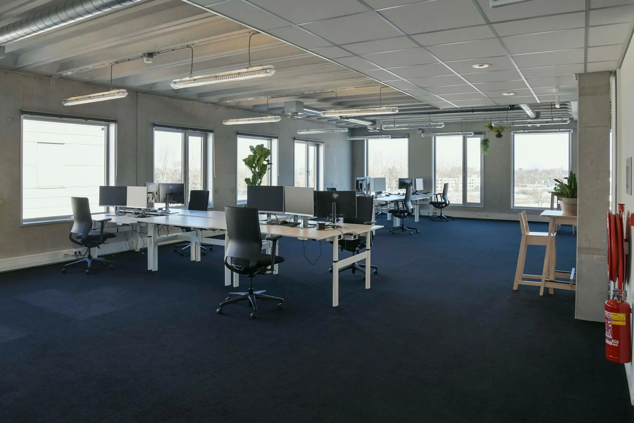 Ruime en moderne kantooretage aan de Bahialaan met werkplekken, grote ramen en planten.