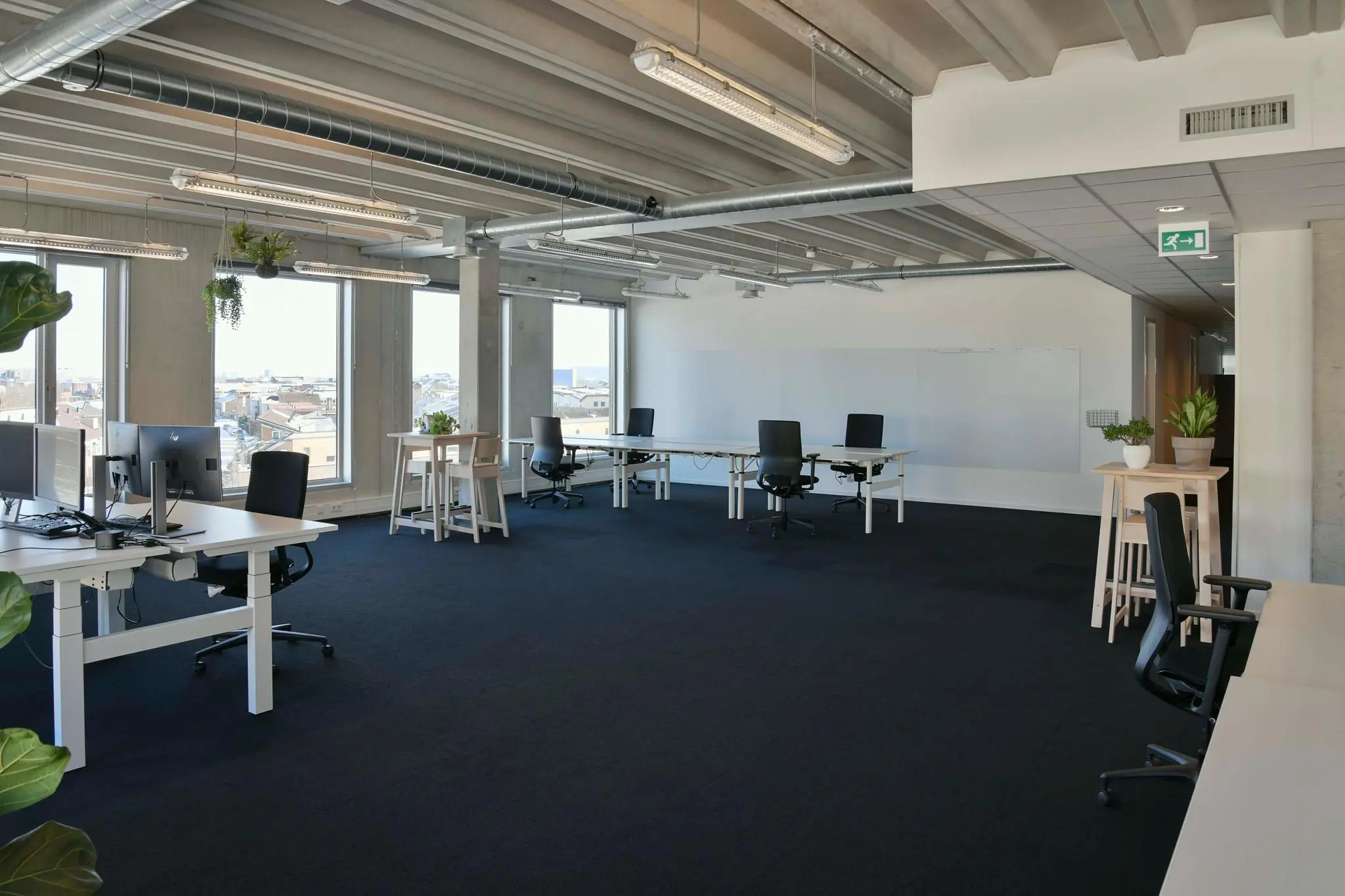 Moderne en lichte kantoorruimte aan de Bahialaan met open werkplekken, grote ramen en groene accenten.