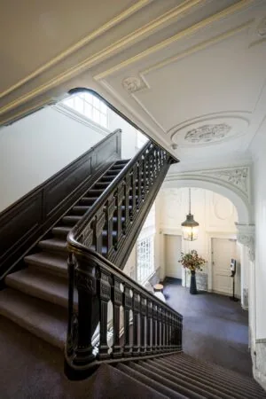 Monumentale houten trap met sierlijke balustrade in een klassiek herenhuis aan de Herengracht.