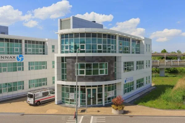 Modern kantoorgebouw aan het Rhijnspoor met glazen gevel en bedrijfsbusje geparkeerd voor de ingang.