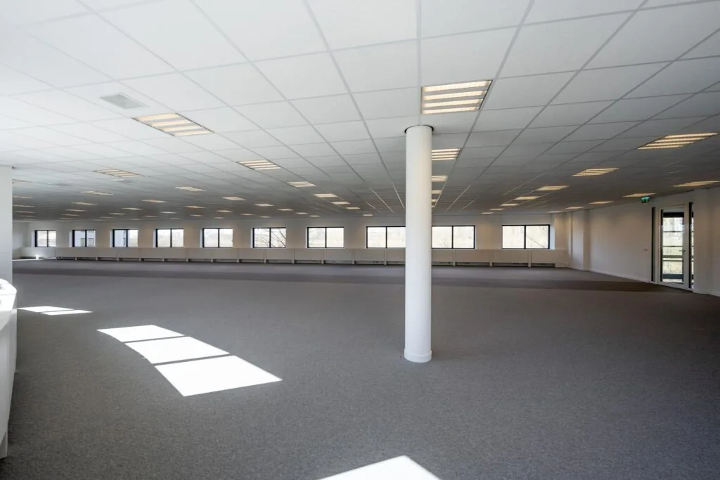 Ruime, lege kantoorruimte aan de Wegalaan met veel ramen en systeemplafond.