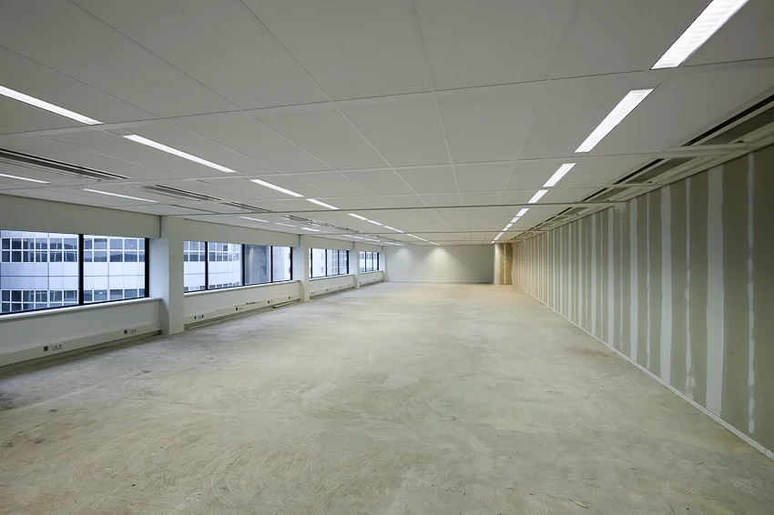 Leeg kantoorpand aan het Weena-Zuid met onafgewerkte vloer en systeemplafond.