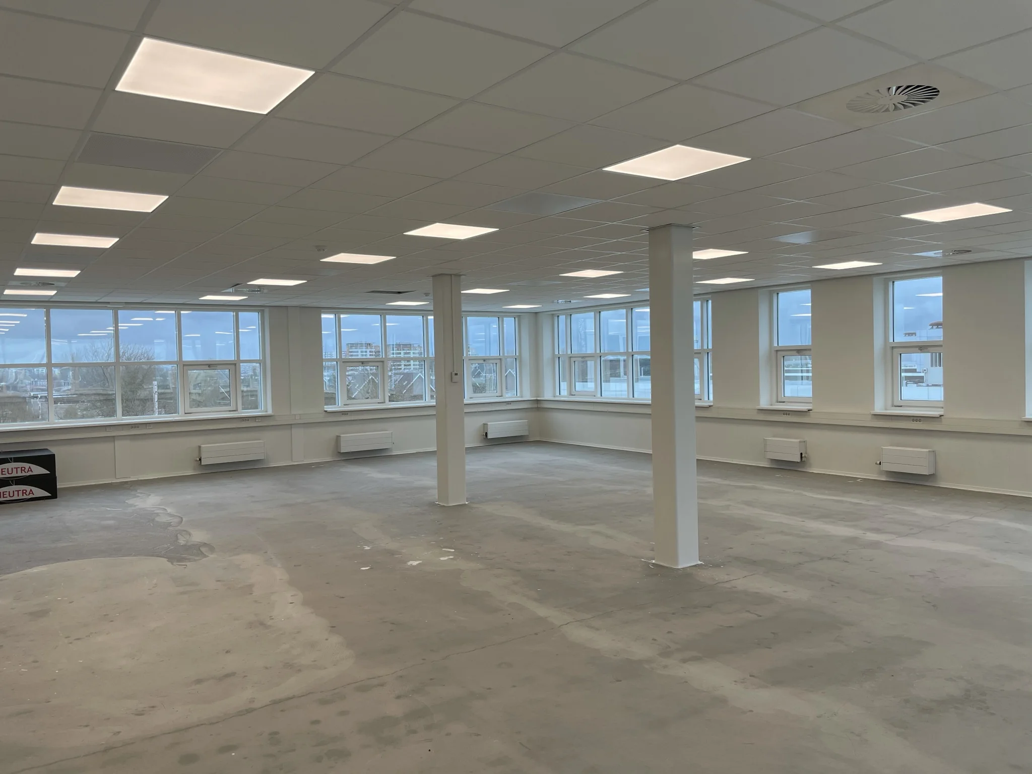 Leeg en licht kantoorpand in Rhijnspoor met grote ramen en systeemplafond.