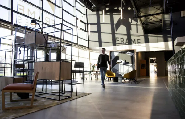 Man loopt door modern ingerichte kantoorruimte met veel natuurlijk licht in gebouw aan de Atoomweg.