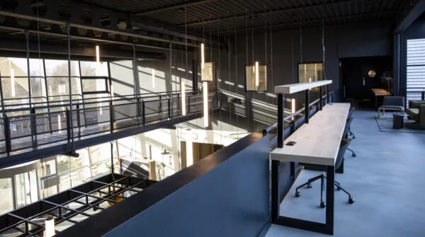 Moderne kantoorruimte aan de Atoomweg met hoog plafond, industriële details en open werkplekken.
