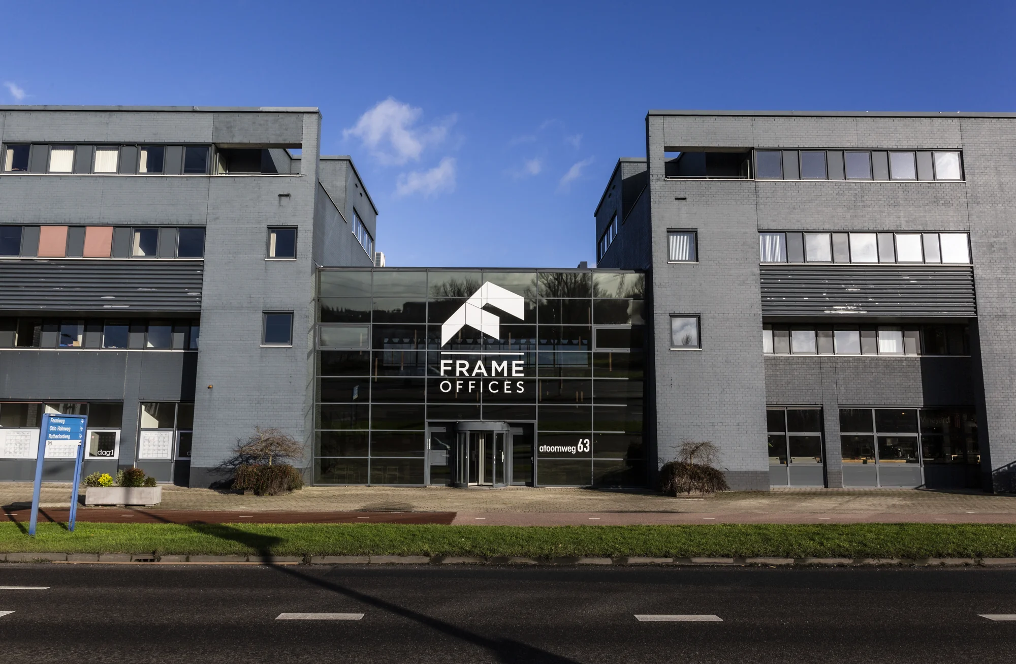 Voorgevel van het kantoorgebouw Frame Offices aan de Atoomweg 63 in een modern grijs pand.