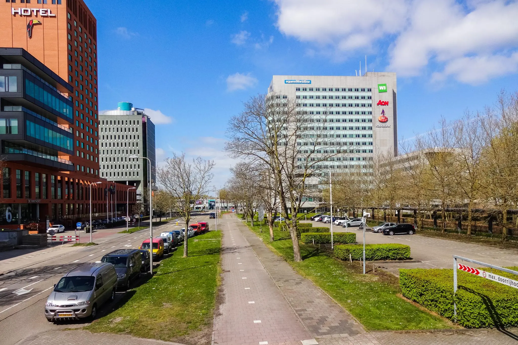 Straatbeeld van de Winthontlaan in Utrecht met kantoorgebouwen, een hotel en een fietspad in het midden.