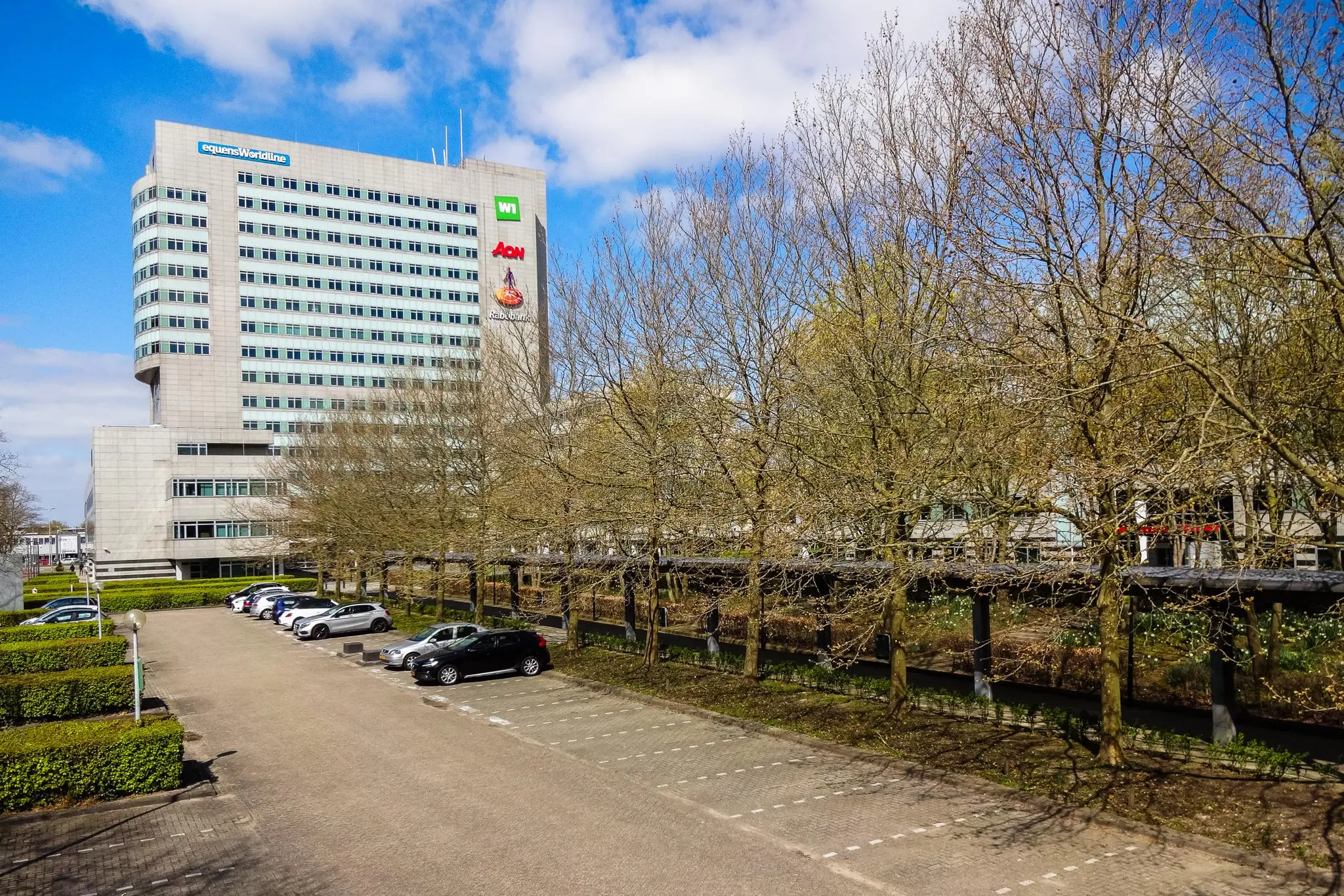 Kantoorgebouw aan de Winthontlaan in Utrecht met parkeerterrein en bomen op de voorgrond.